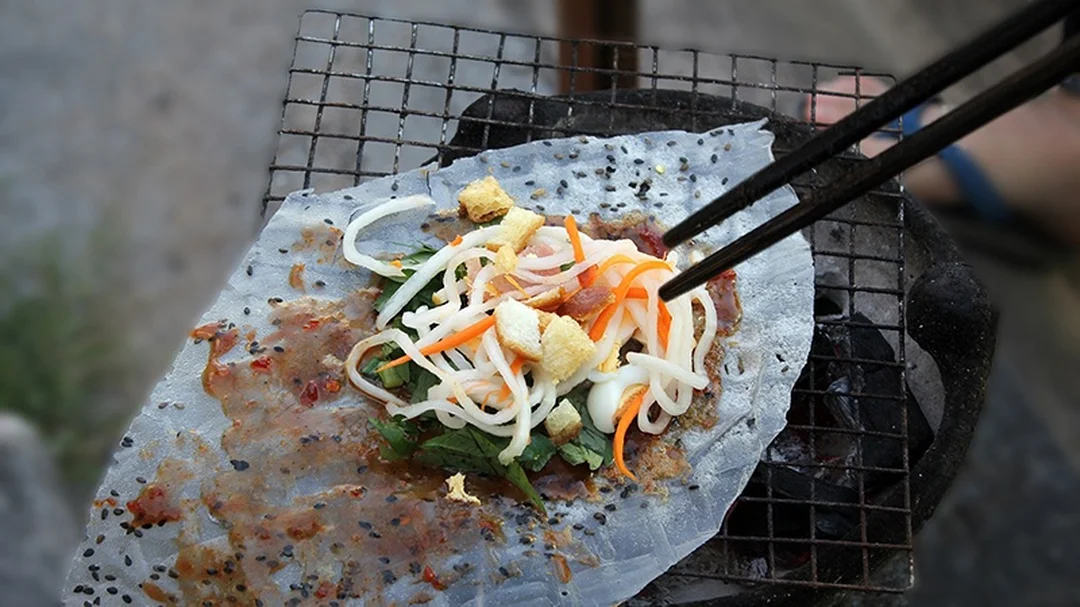 bánh tráng nướng mắm ruốc được cuốn trên vỉ than